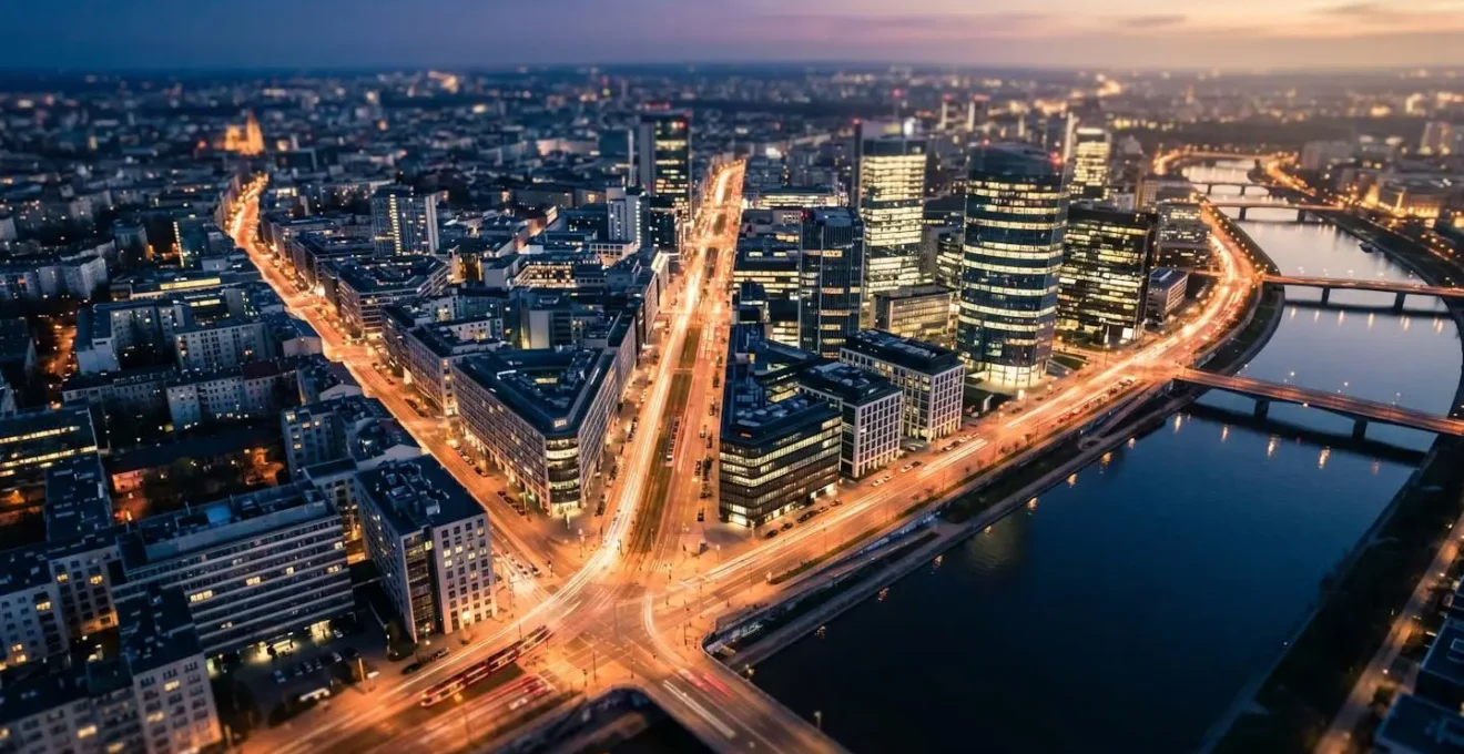 Vue aérienne nocturne d'une métropole moderne avec routes éclairées, immeubles illuminés et réseau de transports visible